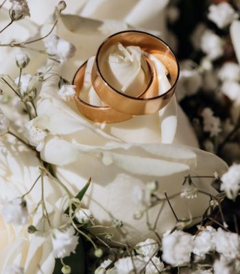 Golden wedding rings on the white rose  from the wedding bouquet